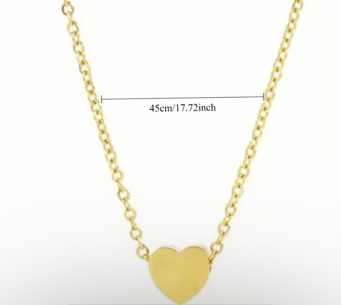 Gold heart pendant necklace on a dark background