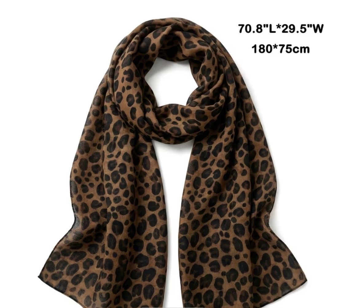 Leopard-print brown scarf with black spots, draped and looped against a white background