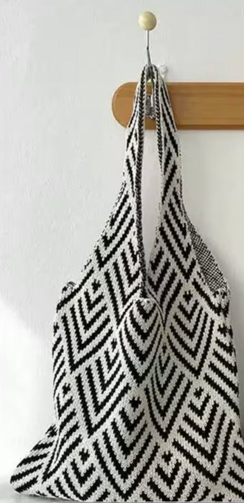 Black-and-white patterned cloth hanging on a wooden hook against a white wall
