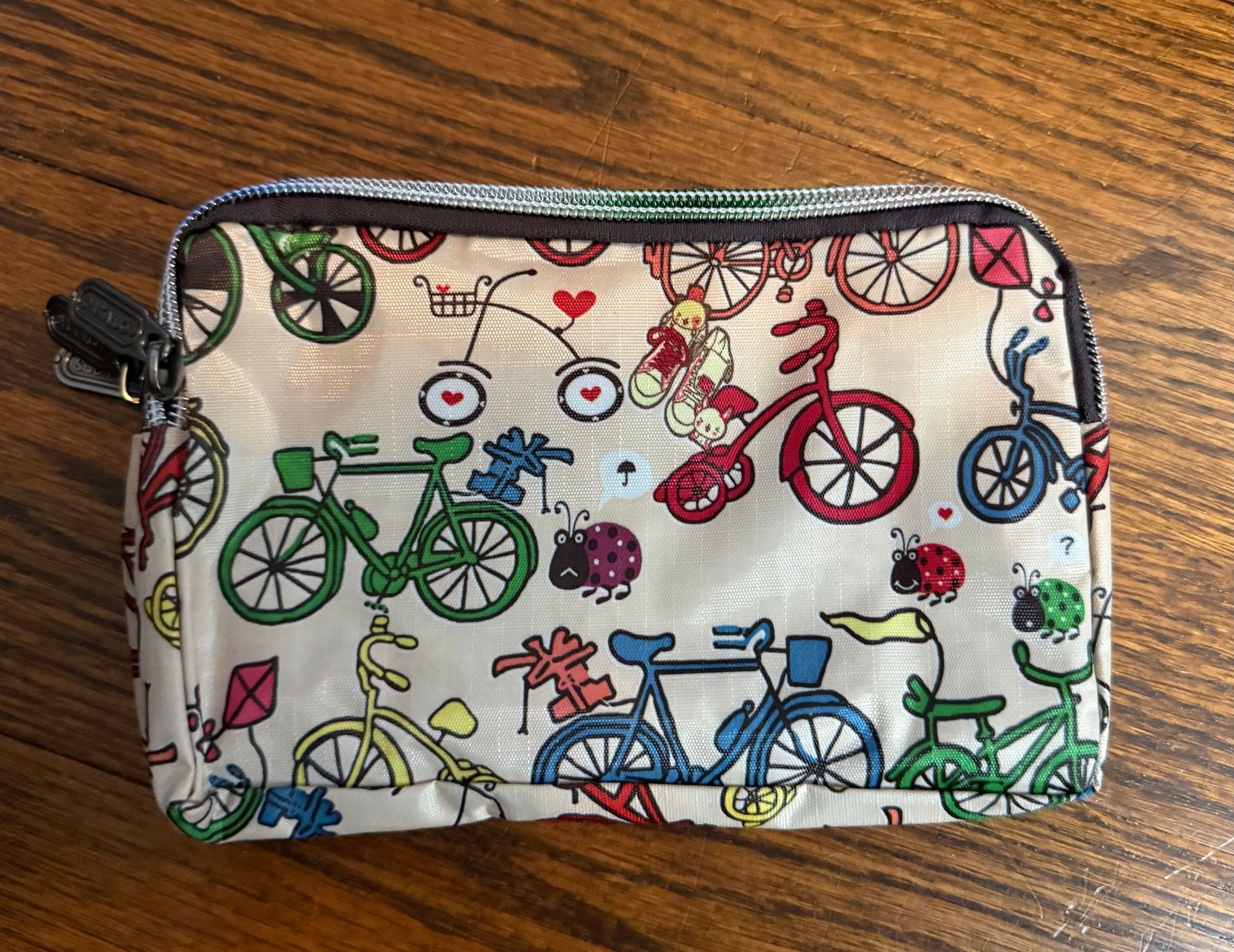 Small white zip pouch with colorful bicycle print