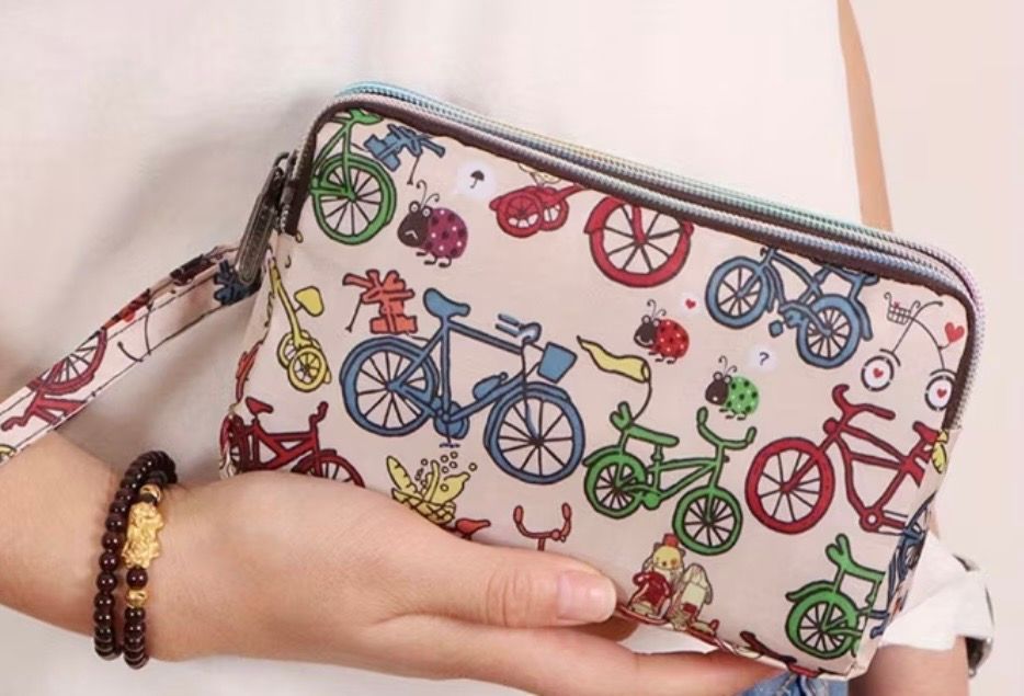 Small white zip pouch with colorful bicycle print
