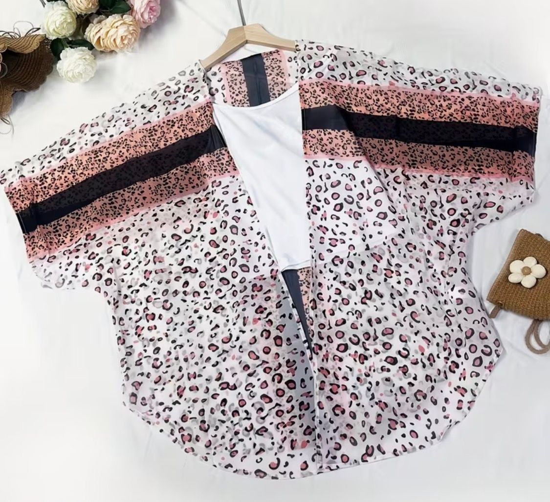 Patterned kimono-style top with pink and black stripes laid flat on a white background