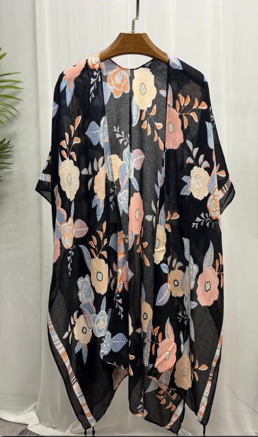 Three floral-patterned kimono-style robes on hangers in soft pink, black, and olive tones