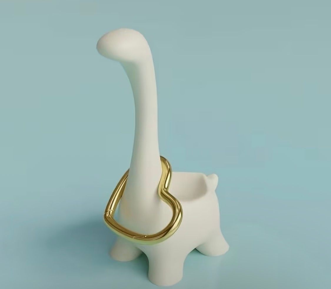 Two small dinosaur figurines, one white and one black, standing side by side on a light background