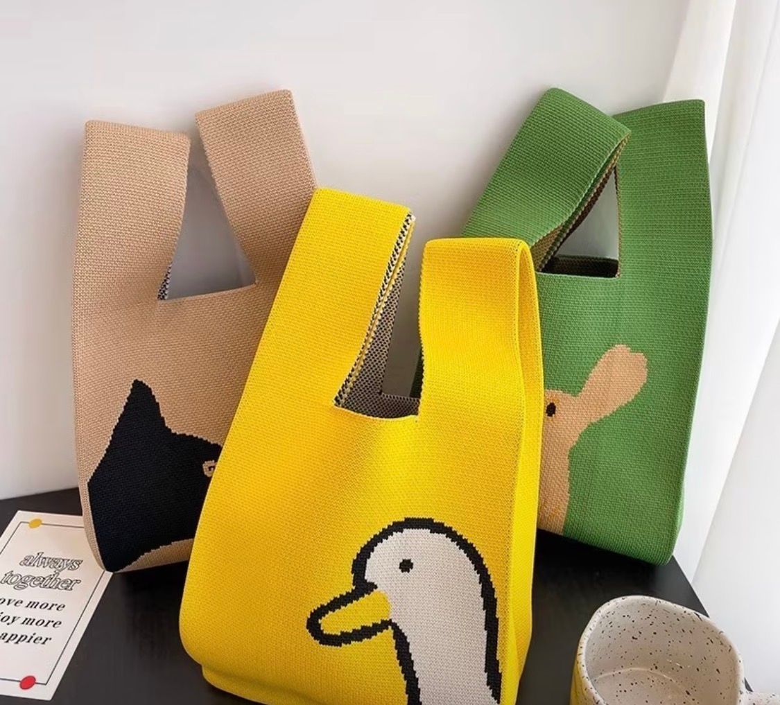 Yellow fabric bag with a small cartoon duck print and folded top