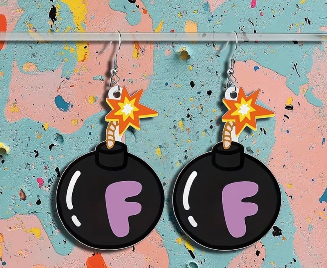 Two cartoon black bombs with lit fuses and purple F letters on a pink and blue speckled wall