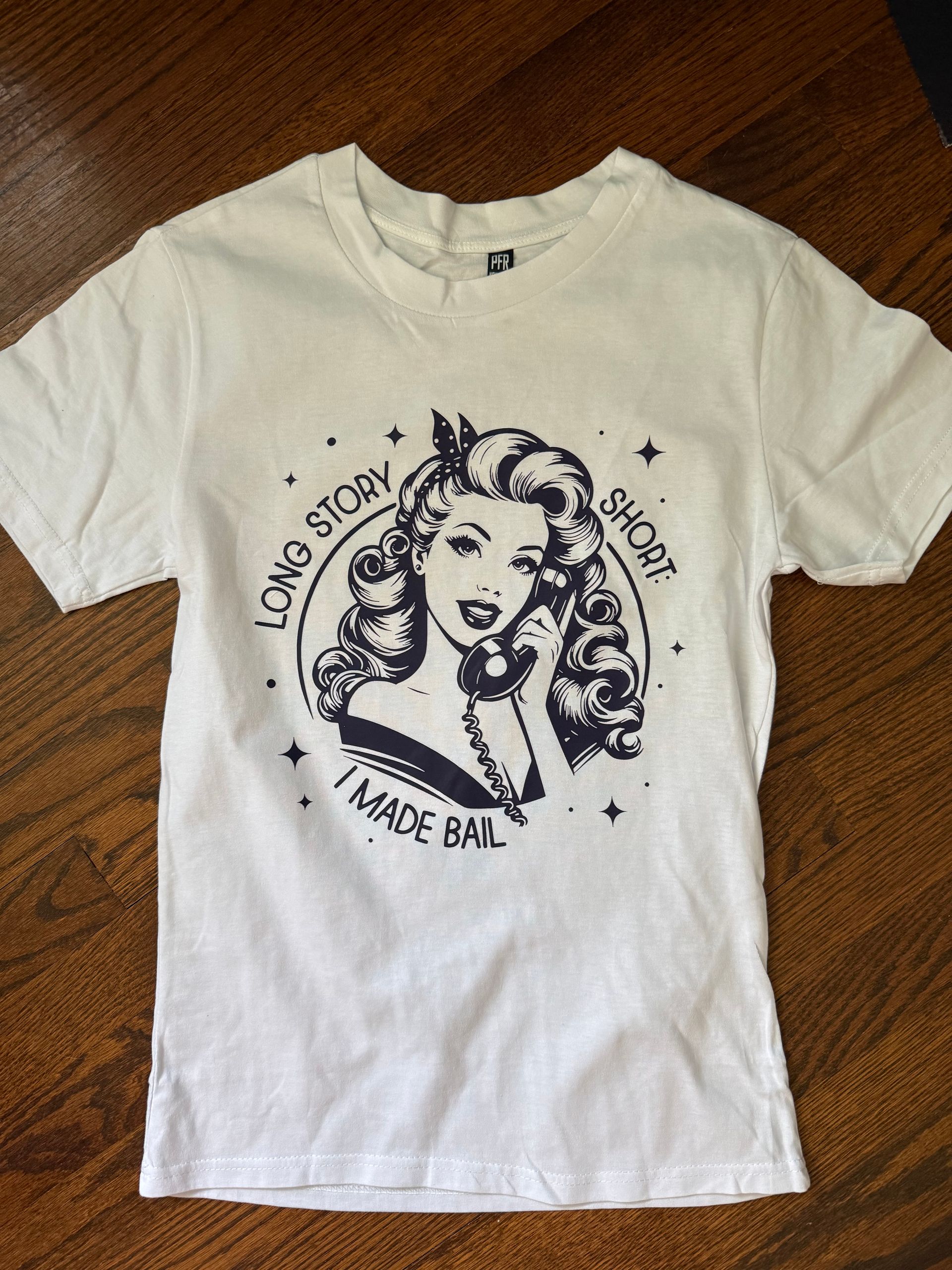 White T-shirt with a black vintage pin-up style graphic and curved text on the chest