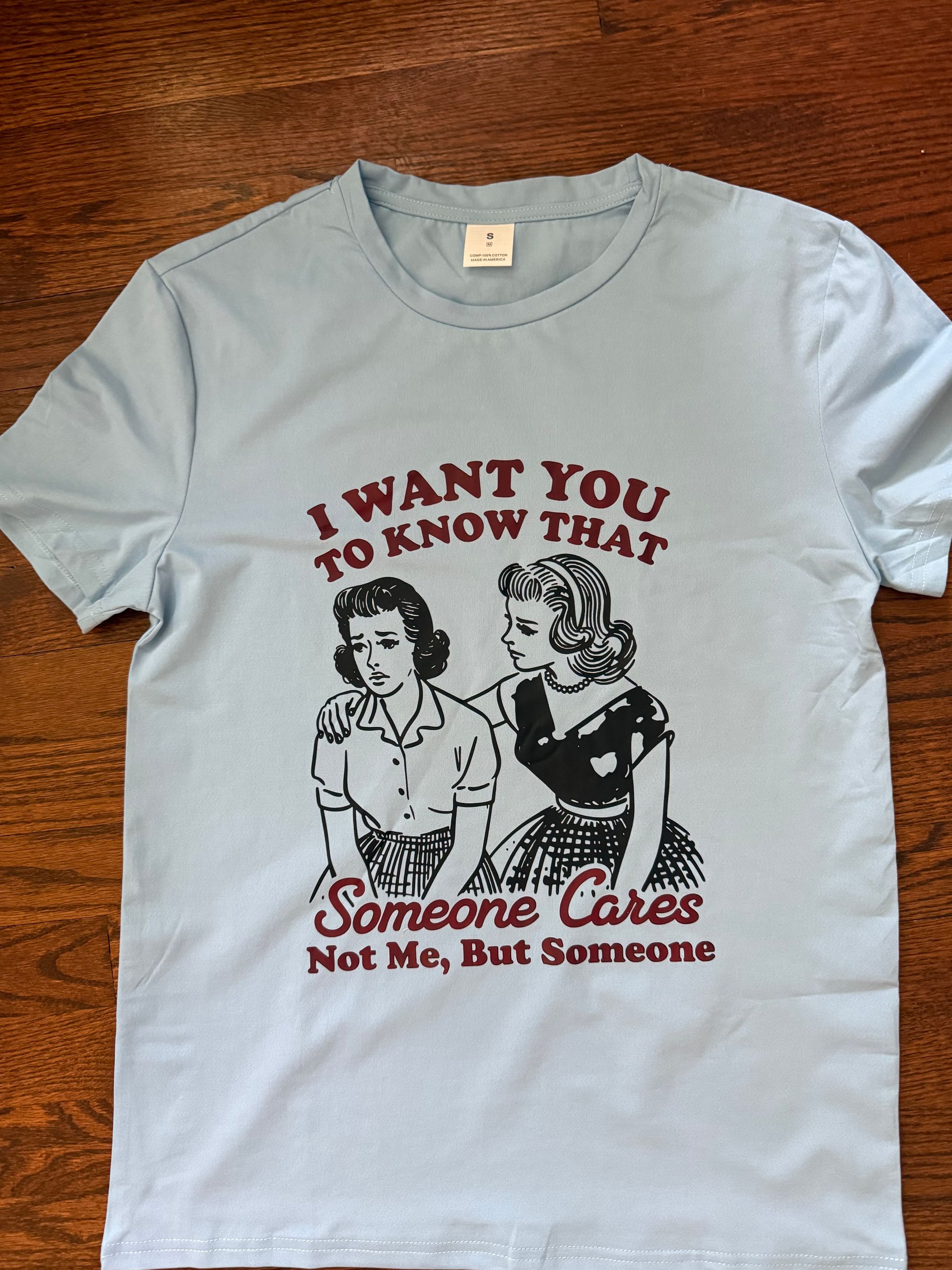 Light blue T-shirt with a black-and-red graphic and the text “I WANT YOU TO KNOW THAT Someone Cares”