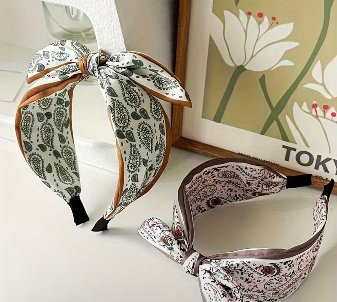 Patterned fabric scrunchies in beige, pink, and green arranged on display with a TOKYO sign behind them