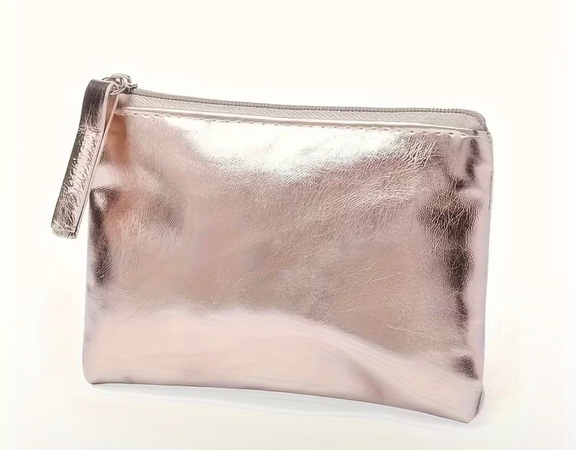 Metallic pink zippered pouch with a tassel on a light background