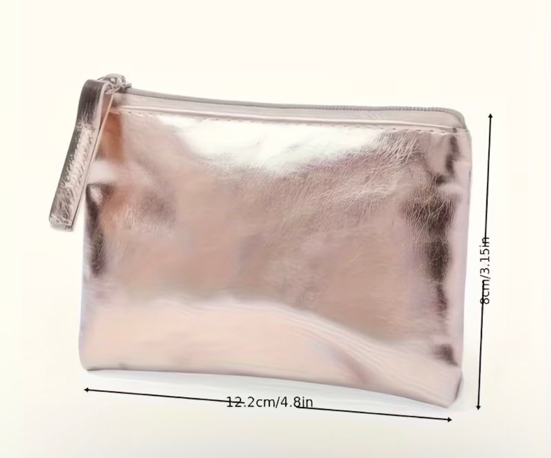 Metallic pink zippered pouch with a tassel on a light background