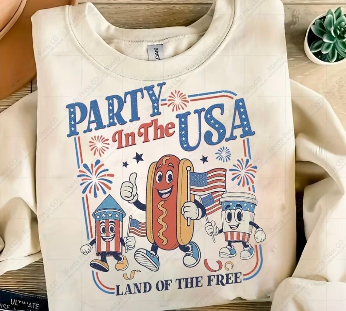 Cream sweatshirt with patriotic “Party in the USA” hot dog graphic and “Land of the Free” text