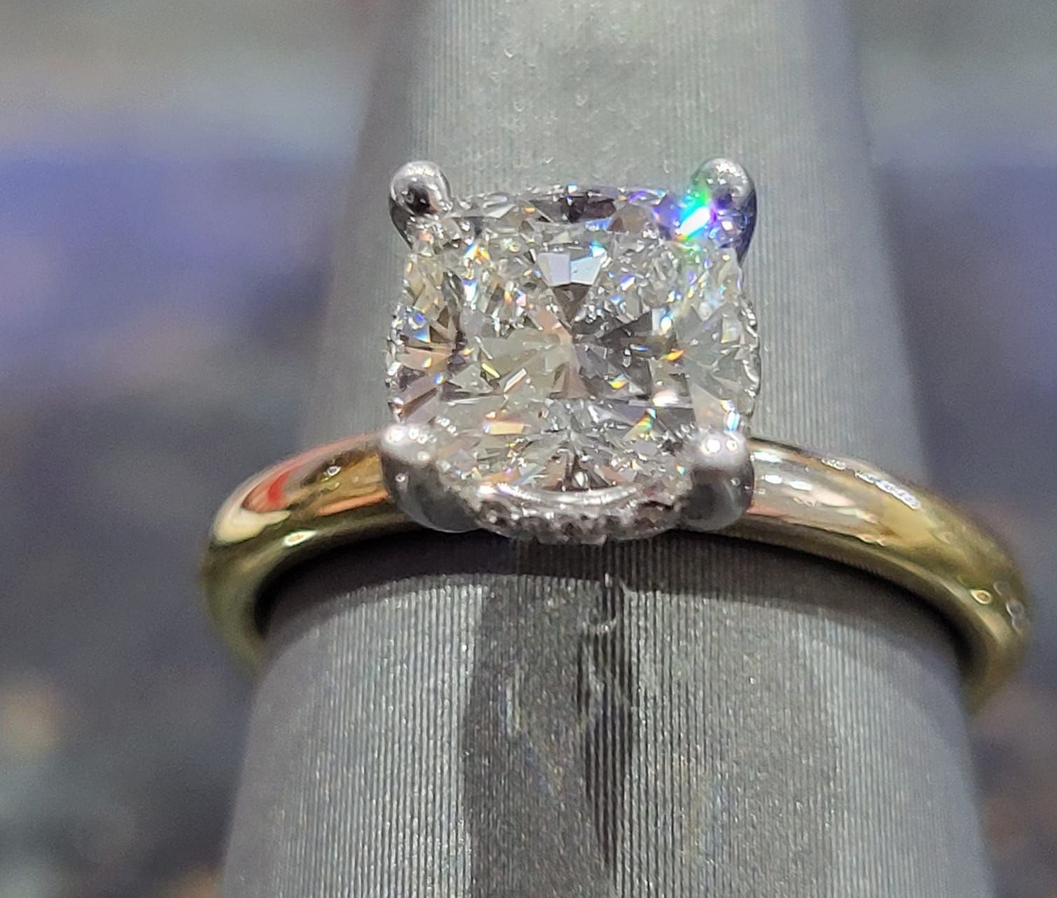 A woman with red nails is wearing a large diamond ring