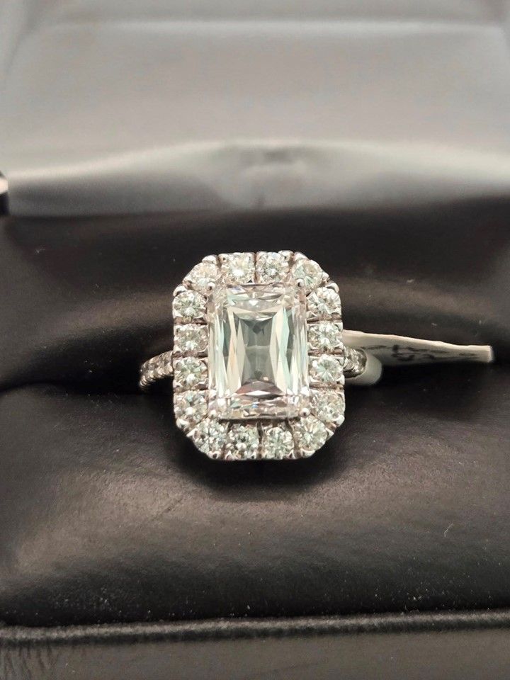 A diamond ring with an emerald cut diamond in the center