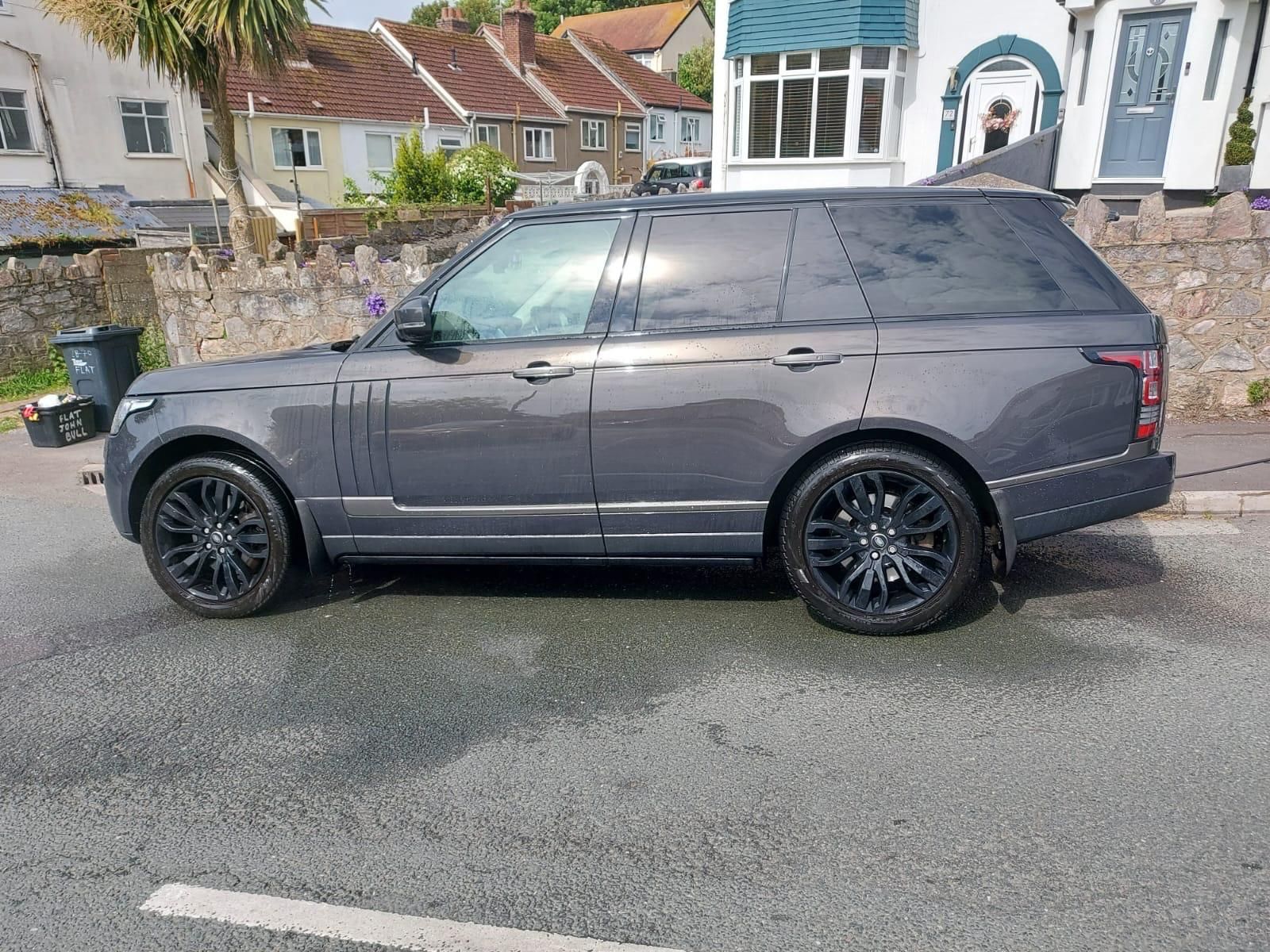 The interior of a range rover sport with white leather seats.
