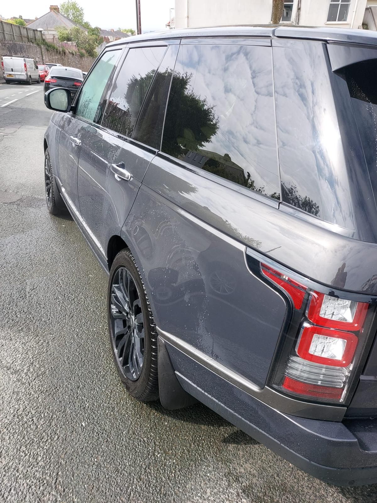 The interior of a range rover sport with white leather seats and a steering wheel has been detailed.
