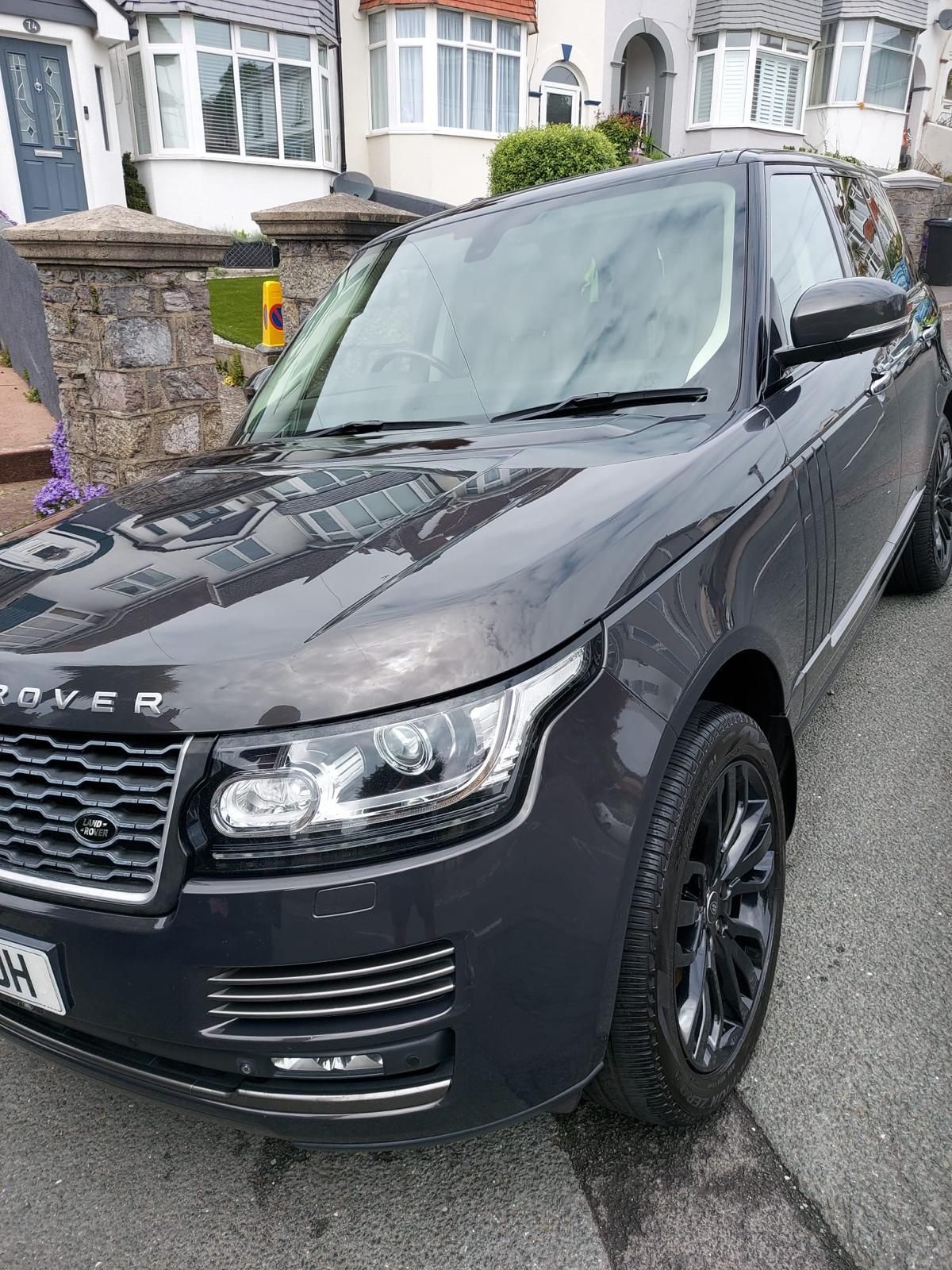 The interior of a range rover sport with white leather seats.