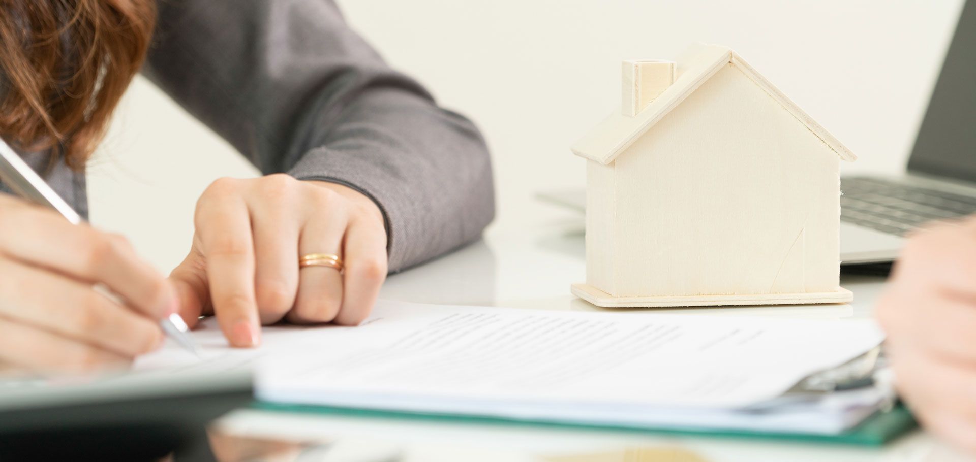 A woman signs a contract with a real estate agent in Medina, OH, assisted by LARIBEE LAW, LLP