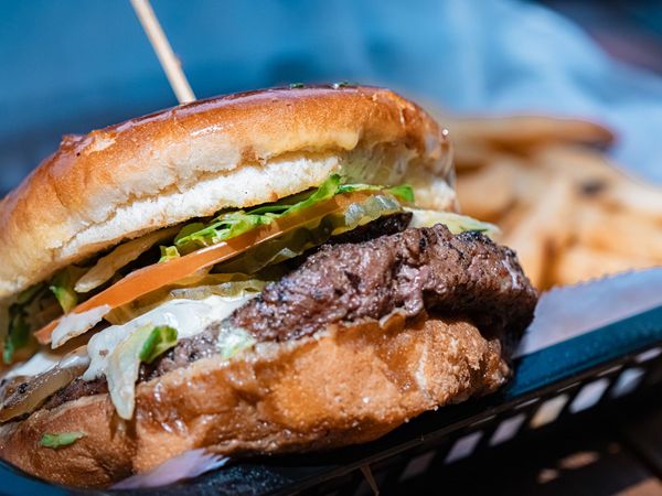 A plate of fried green beans with dipping sauce on a table.