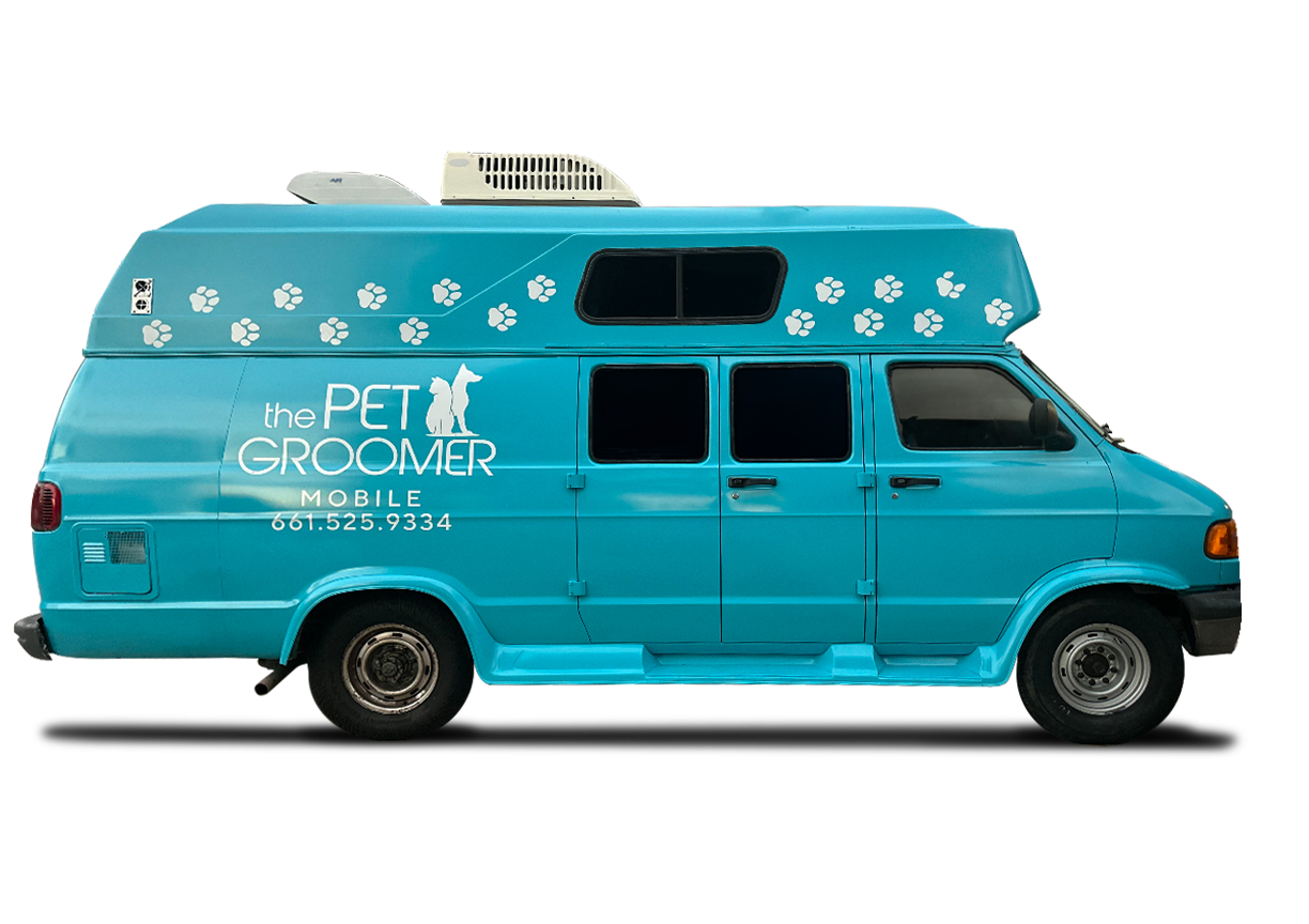 A blue van that says the pet groomer on it