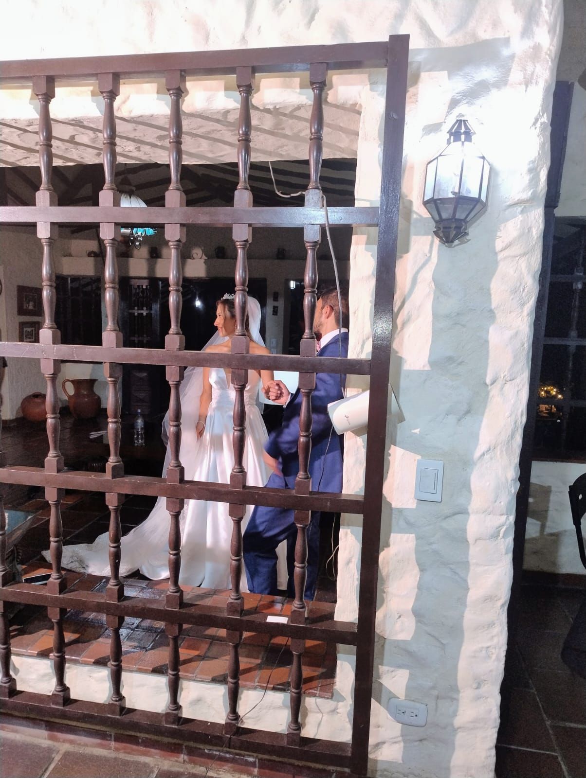 Una mano enguantada pasa un paño rojo por el capó blanco de un coche, cerca de un faro brillante.