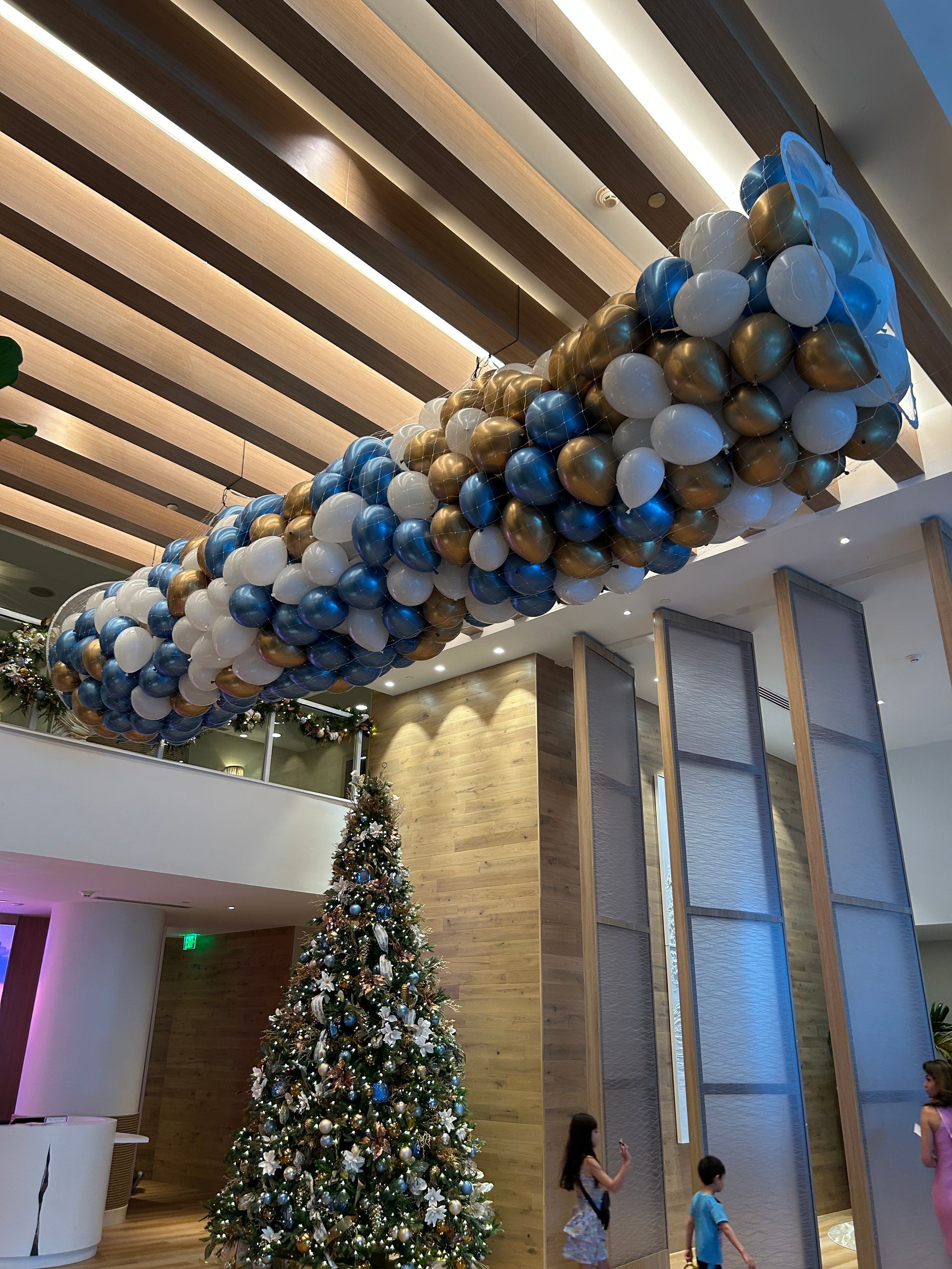 A red white and blue balloon arch in front of a glass door