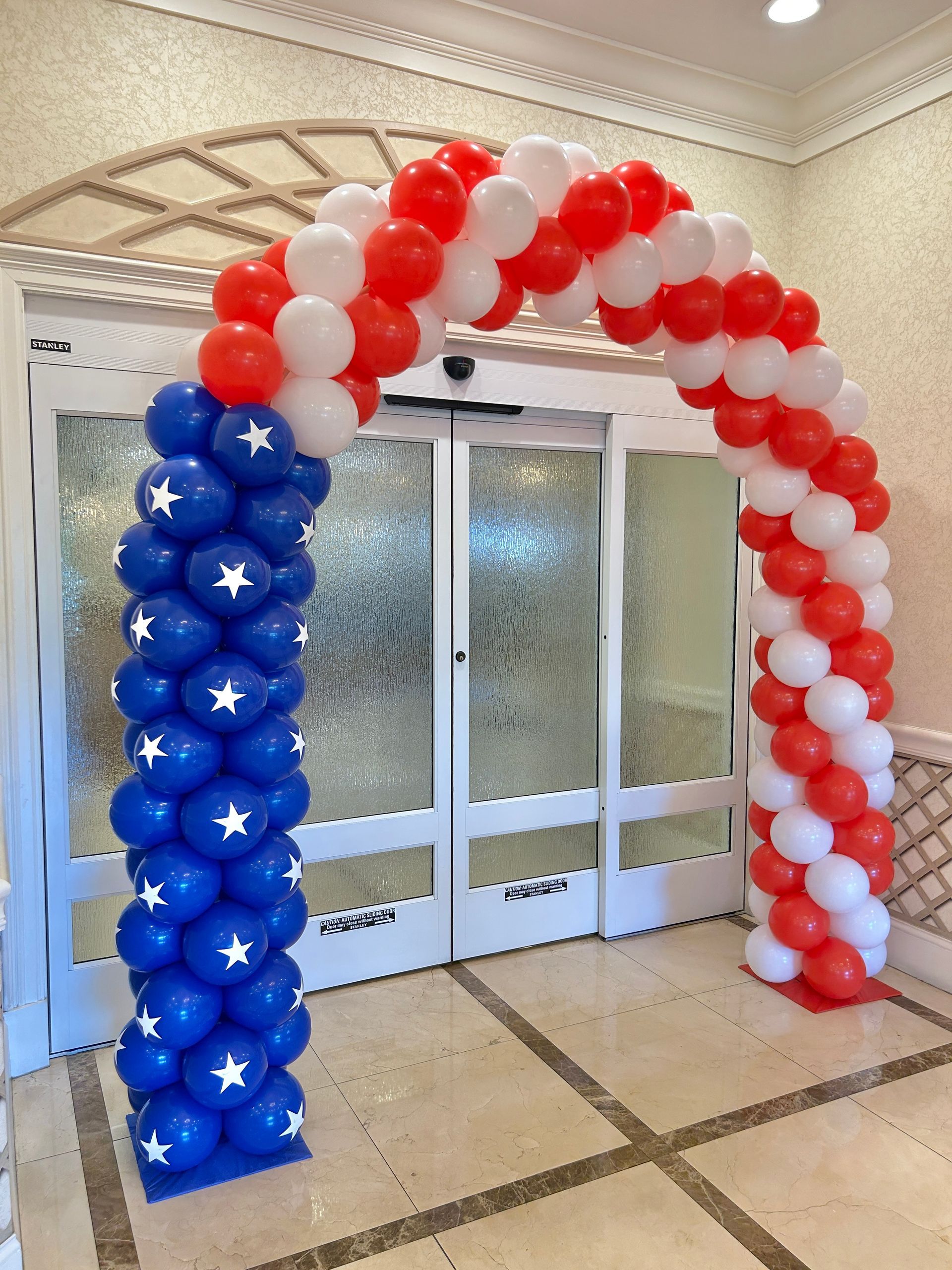 A purple wall with pink and purple balloons and butterflies on it.
