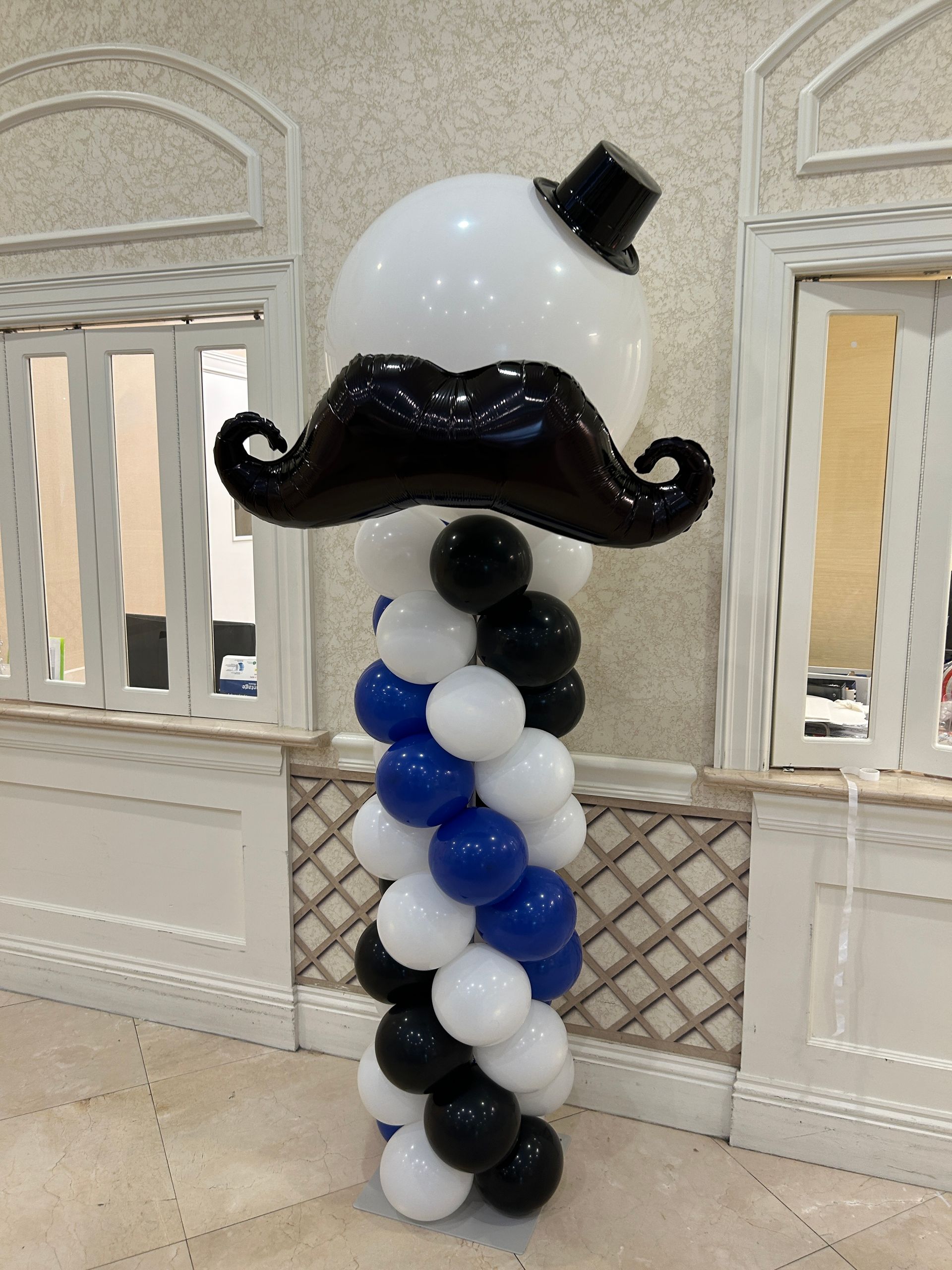 A purple wall with pink and purple balloons and butterflies on it.