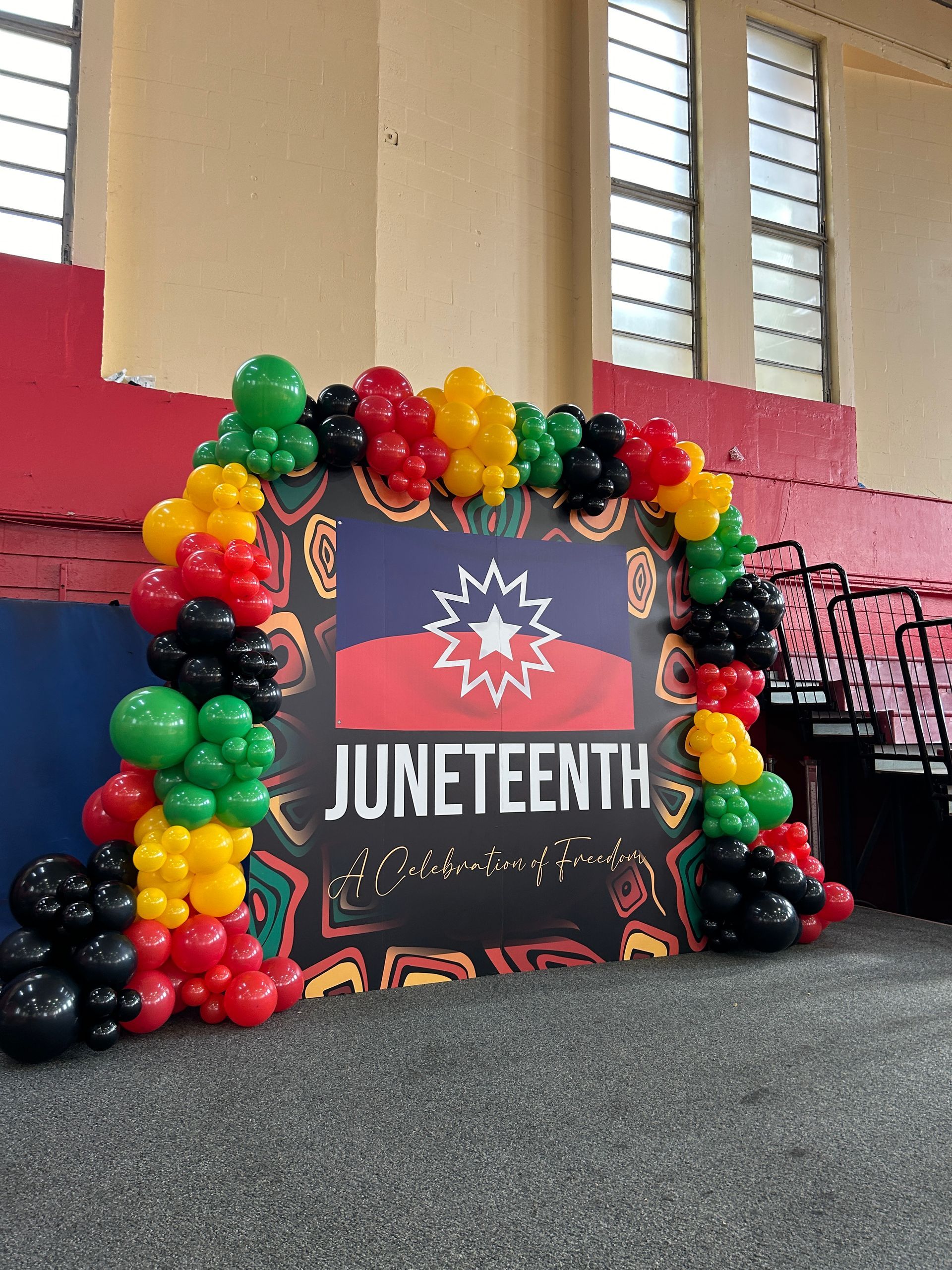 A purple wall with pink and purple balloons and butterflies on it.
