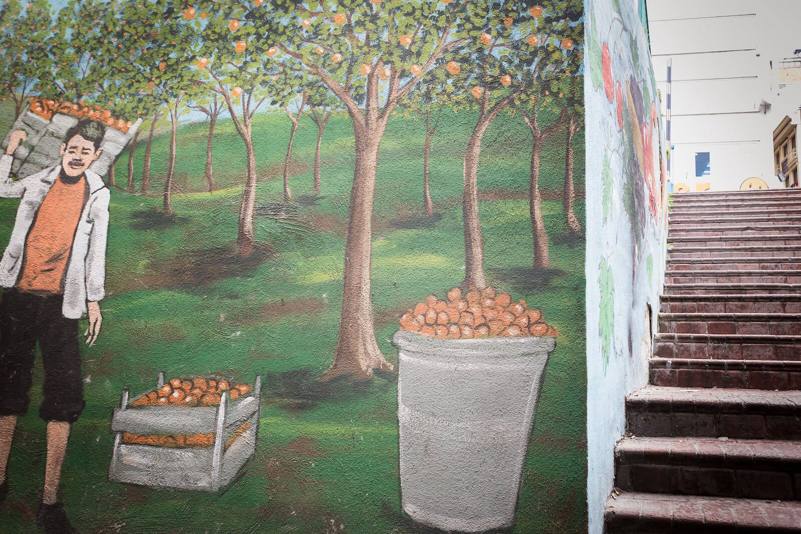 A painting of a man picking apples in an orchard next to a staircase.