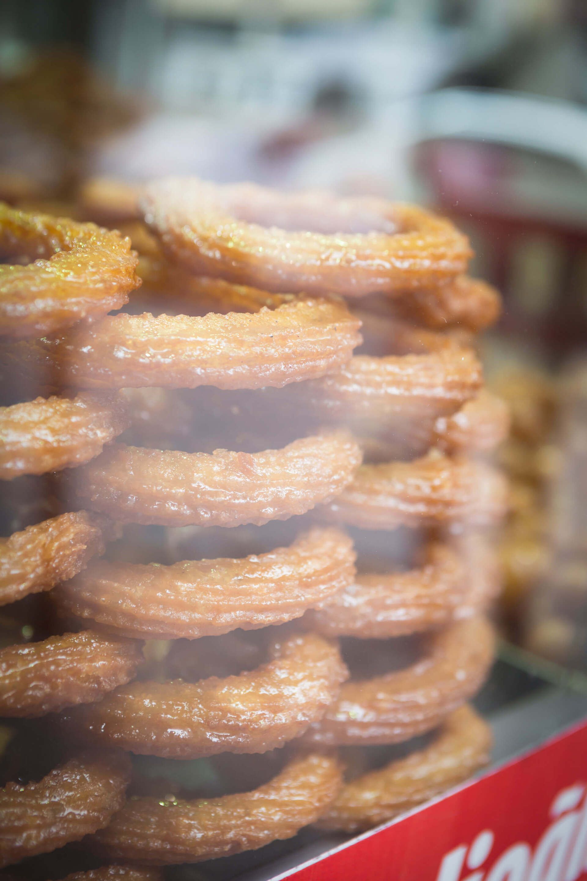A close up of a stack of churros in a glass case.