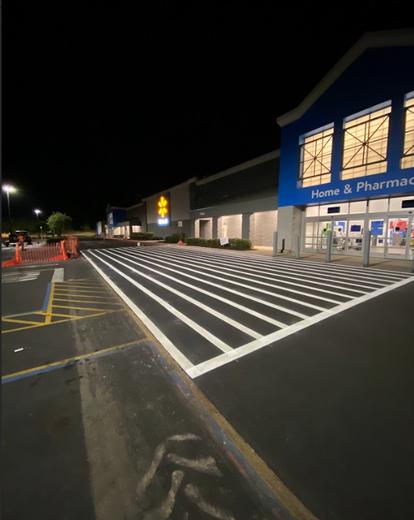 A man in a yellow jacket is cleaning a house with a high pressure washer.