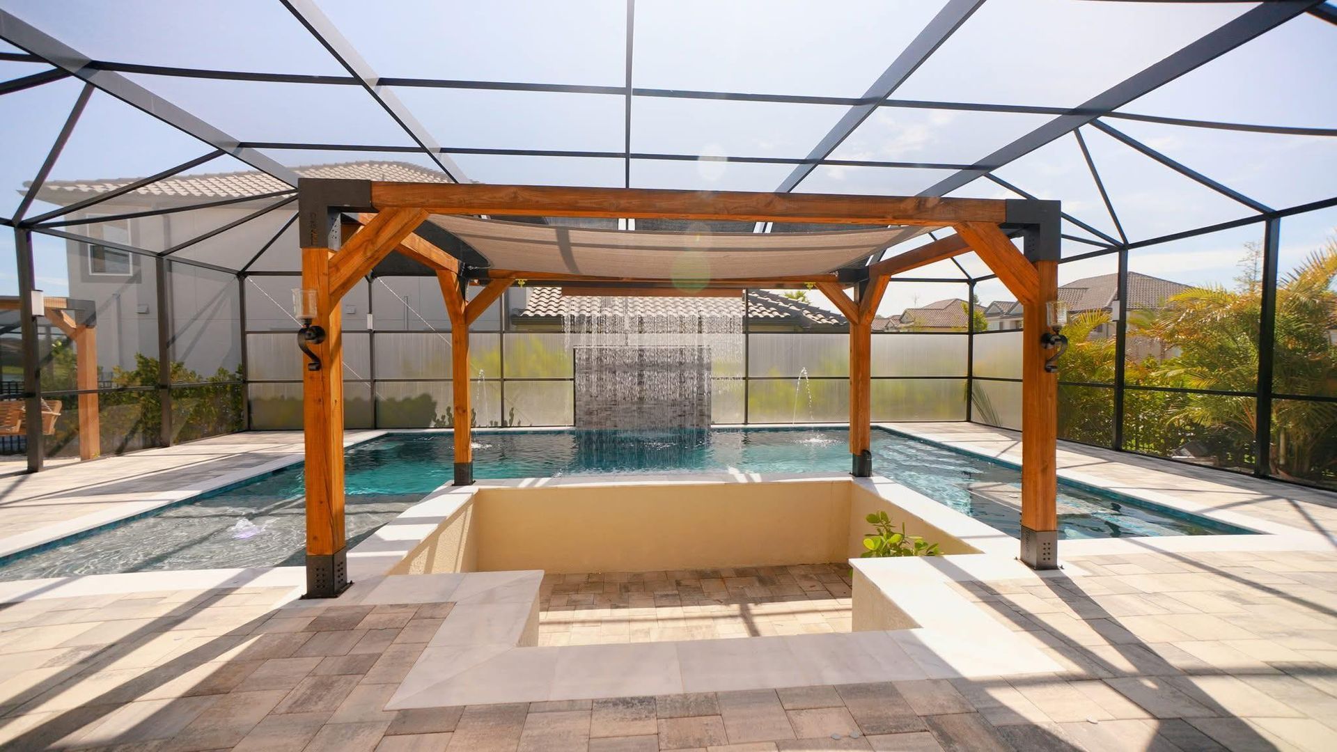Pool area with a pergola, water feature, and screened enclosure.