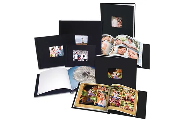Black photo albums, some open, displaying printed photos, on a white background.
