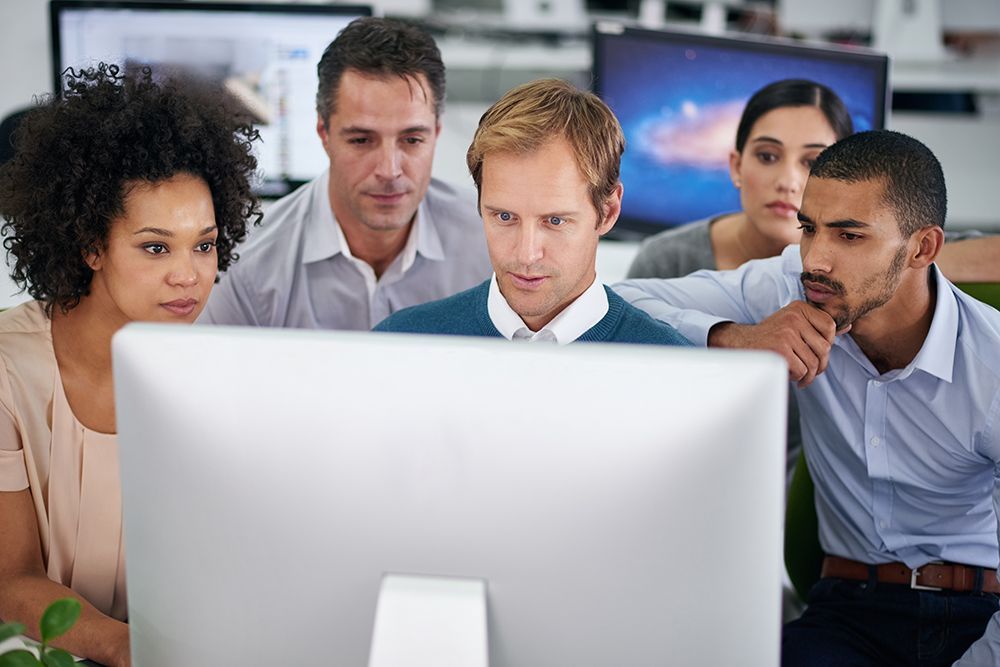 a group of people looking at a computer screen