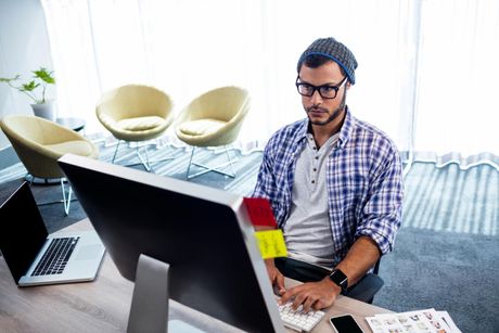 a man sitting in front of a computer on a desk