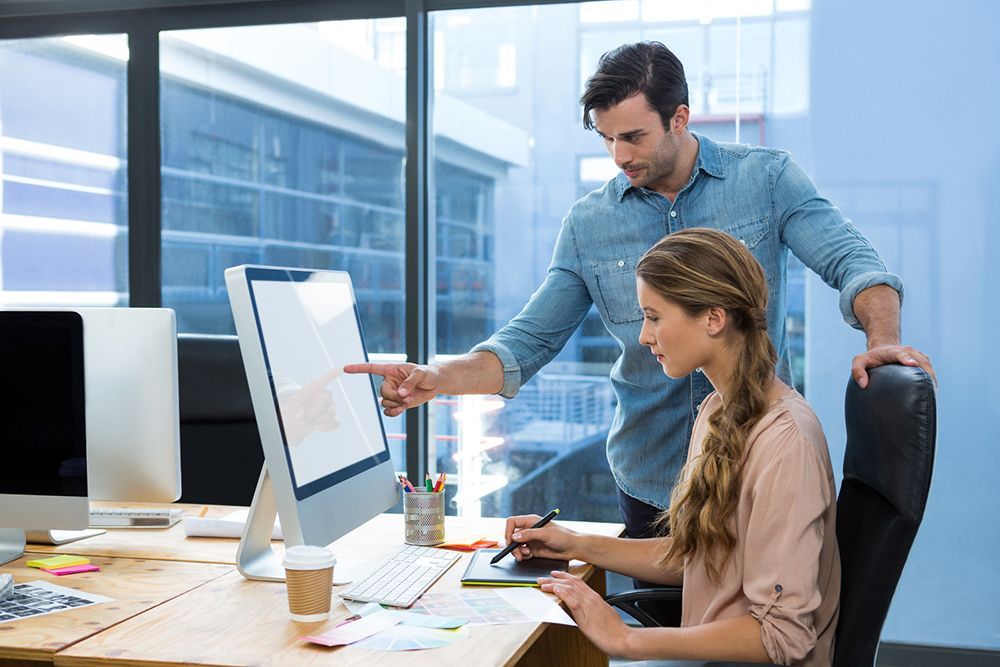 a man and a woman working on a computer