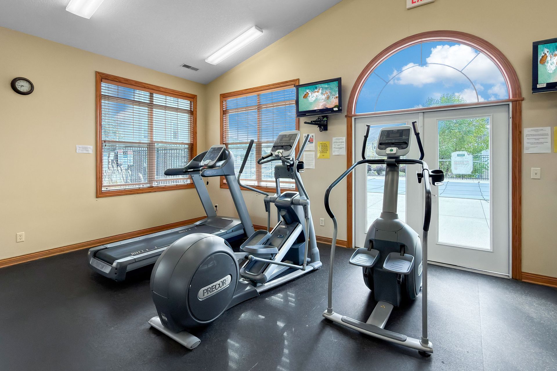Swimming pool with apartment buildings, blue sky, and lounge chairs.