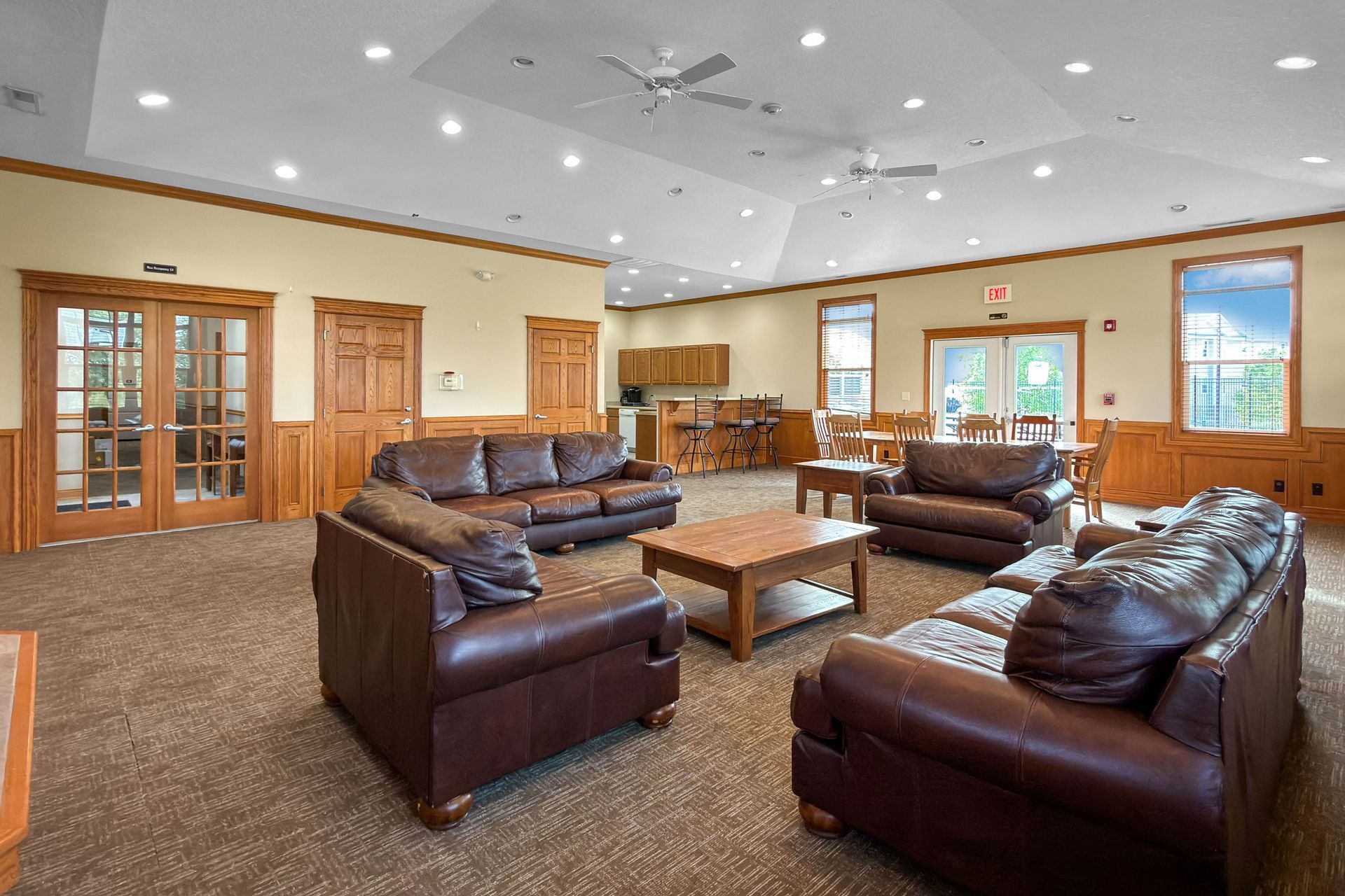Open living room with kitchen, fireplace, and beige walls.