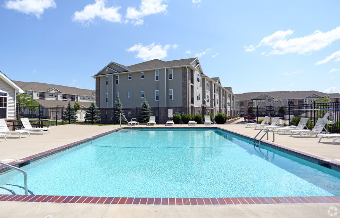Swimming pool with buildings in the background on a sunny day.