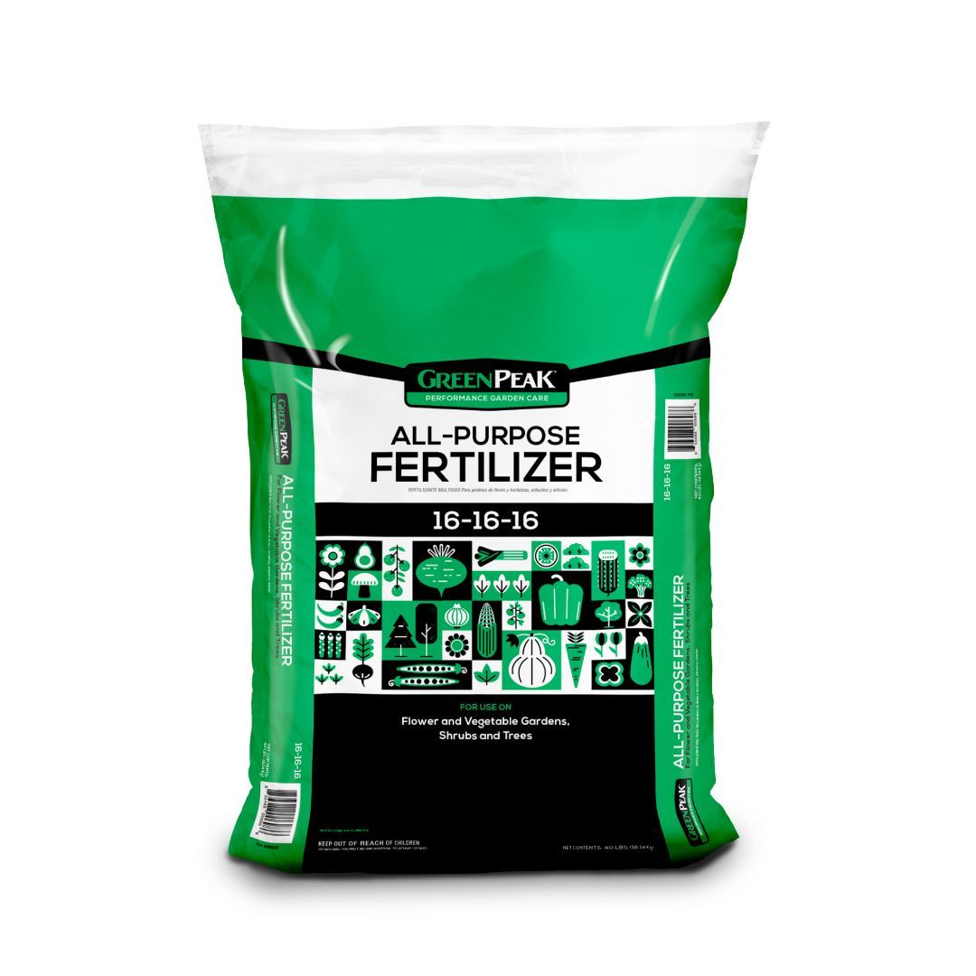 A white, black and green bag of green peak all purpose fertilizer 12-12-12 with veggies, flowers, shrubs, and trees 