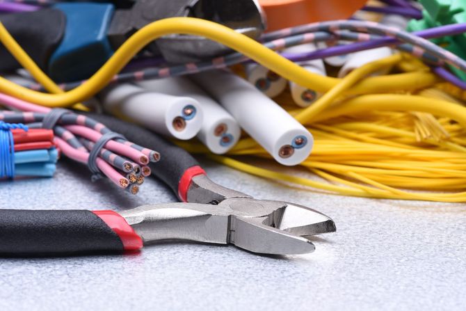 A pair of pliers sitting on top of a pile of wires.