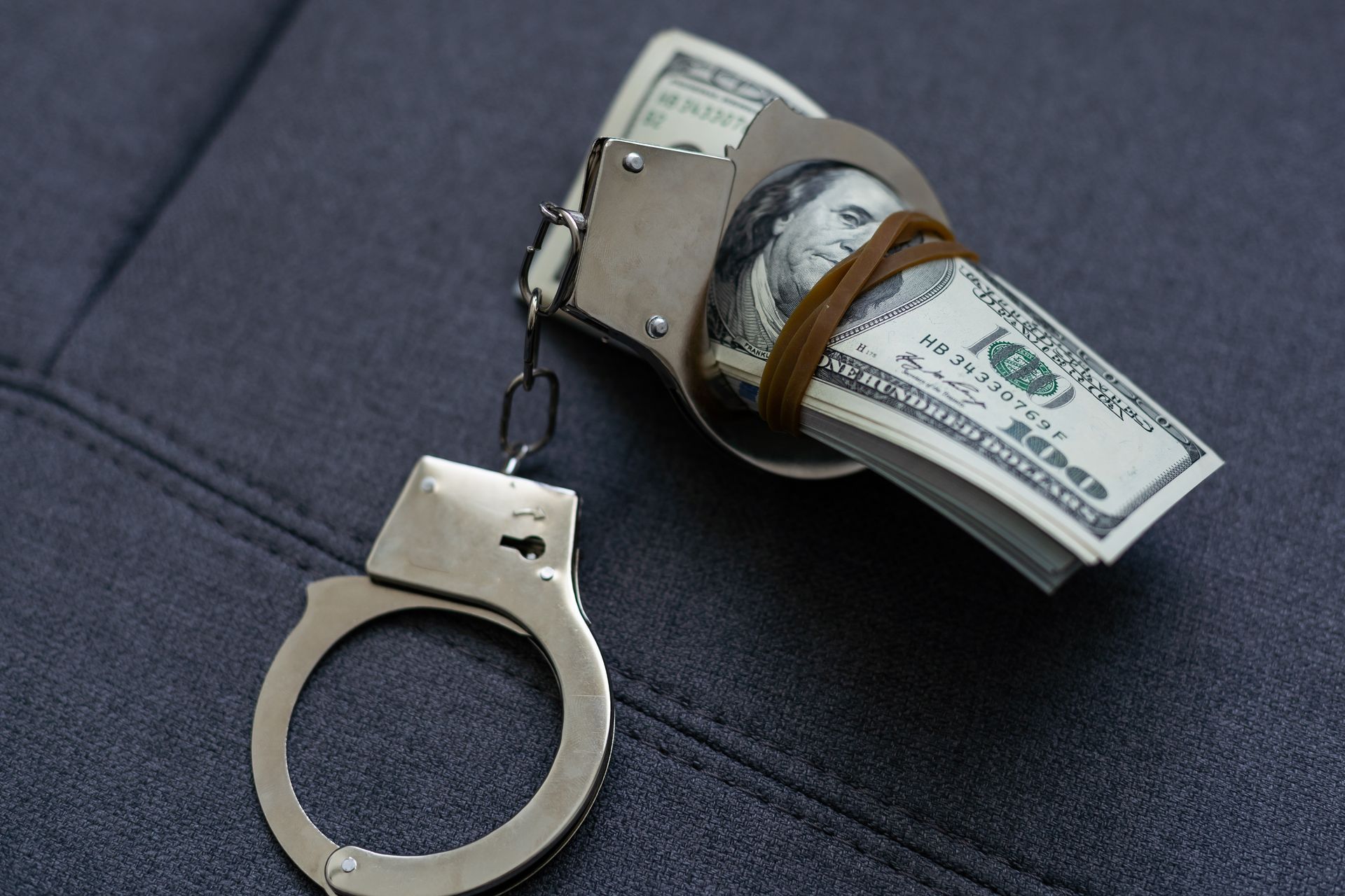 A pair of handcuffs holding a stack of money