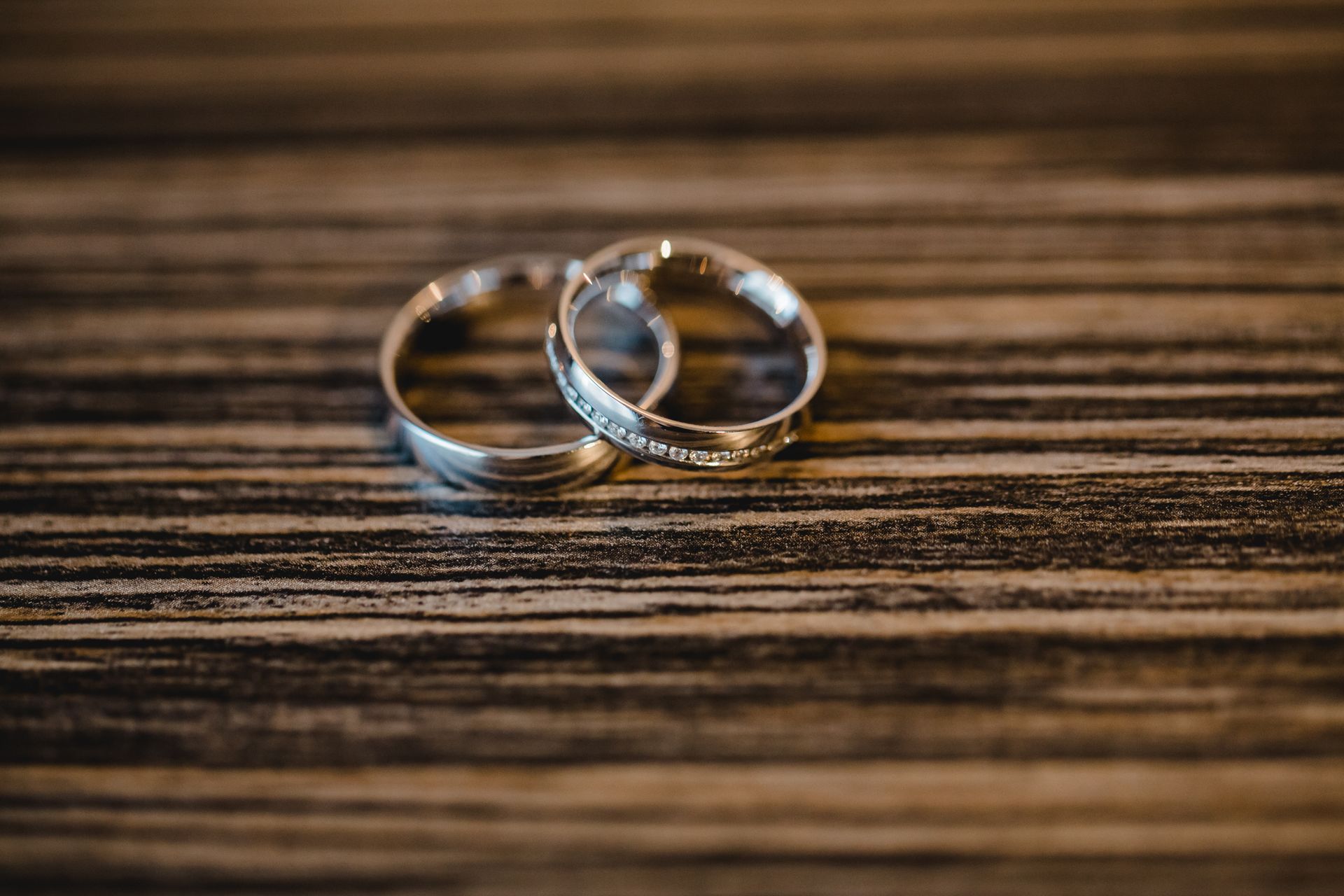 A pair of wedding rings sitting on top of a wooden table.