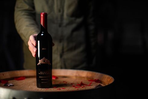 Wine bottle on a textured copper surface; label reads 