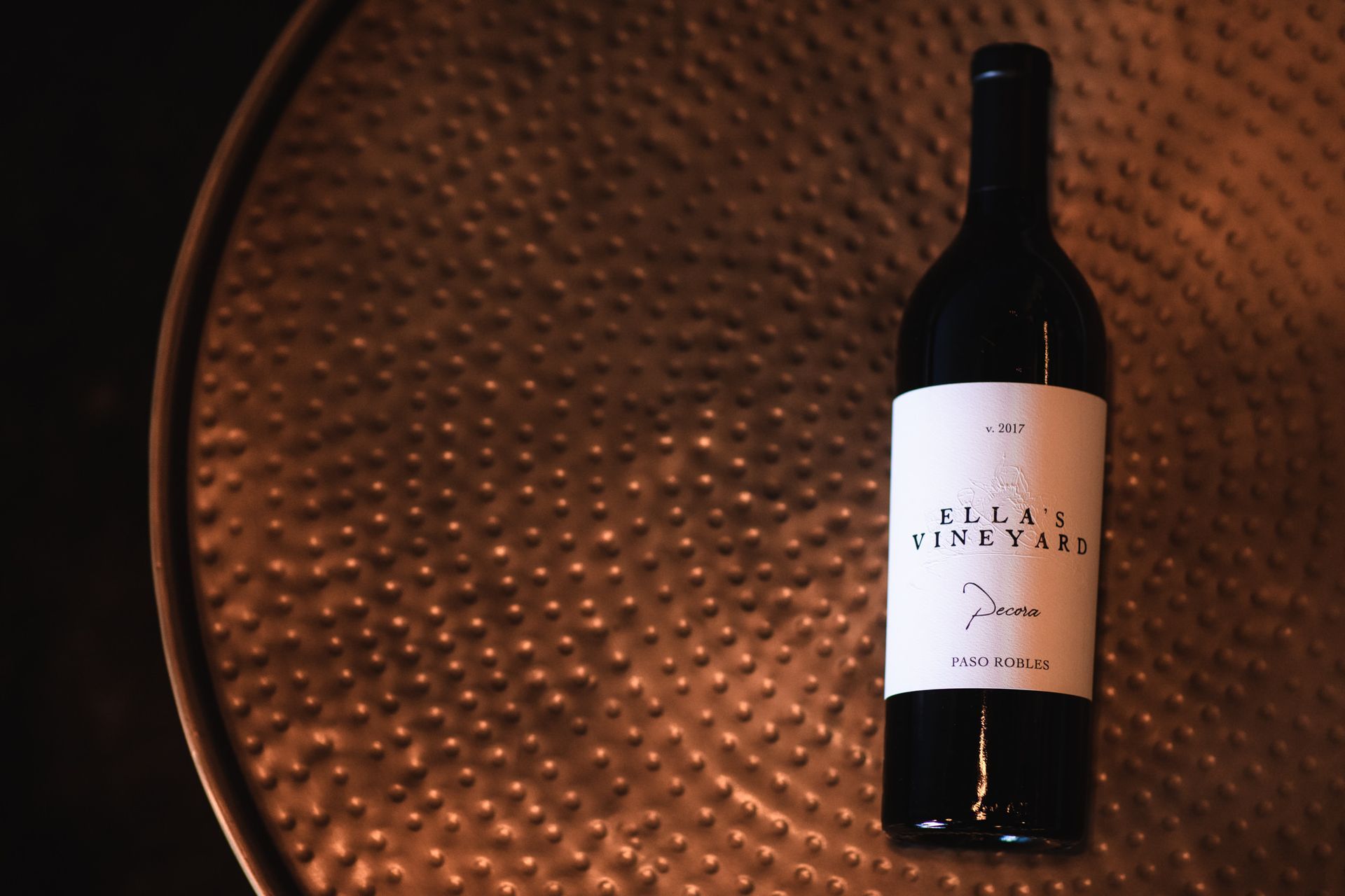 Wine bottle on a textured copper surface; label reads 