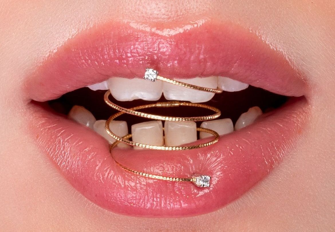 Un primo piano della bocca di una donna con un anello