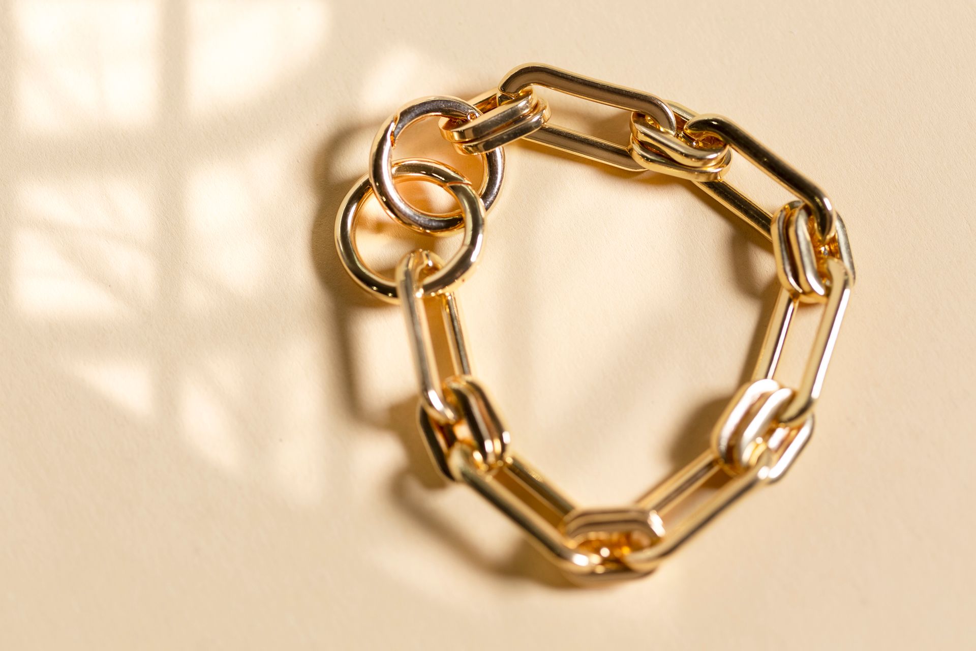 Primo piano di un braccialetto a catena d'oro su un tavolo.