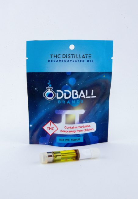 A bag of oddball brand thc distillate next to a cartridge