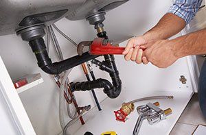 plumber working with a red wrench